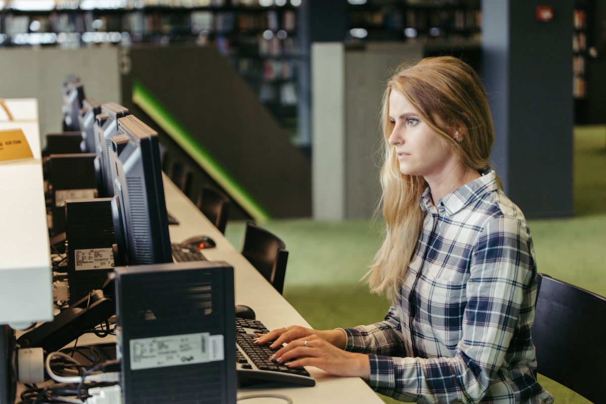 Une femme technicienne en informatique devant un pc pour un dépannage informatique